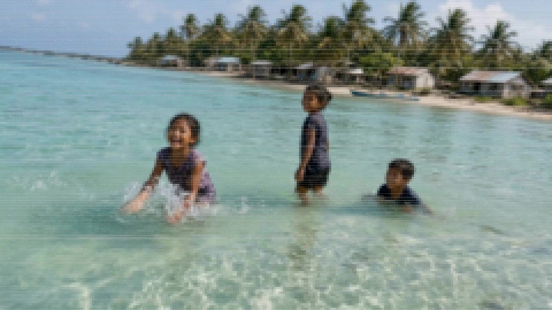 The picture on the monitor resolves from blocky pixels into a clear image.